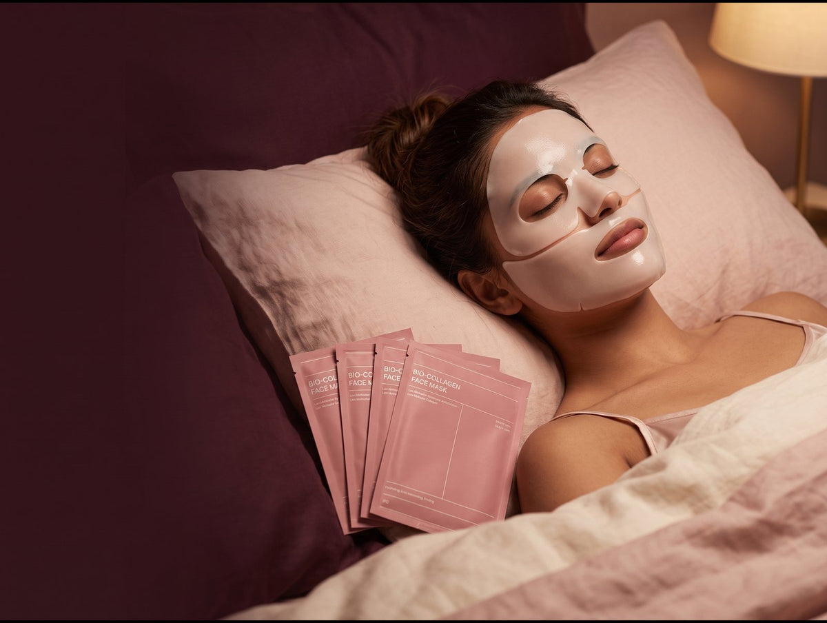 Woman relaxing in bed wearing a two-piece bio-collagen hydrogel mask, with a pack of 4 masks beside her